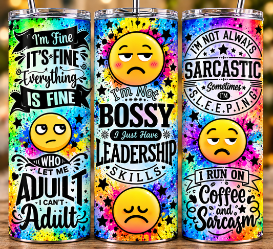 Three colorful 20oz skinny tumblers with funny sarcastic sayings and emoji faces on a bright paint-splatter background